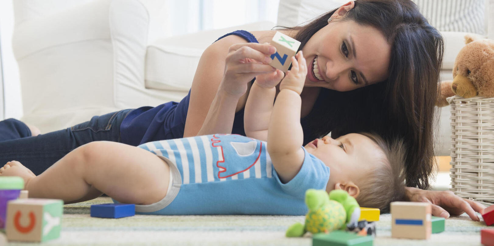 Mixed race mother playing with baby on floor